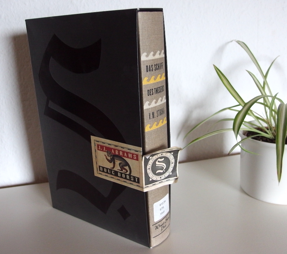 Das Buch "Das Schiff des Theseus" sieht aus wie ein altes leinengebundenes Buch und steckt in einem Schuber mit einem Papiersiegel davor.