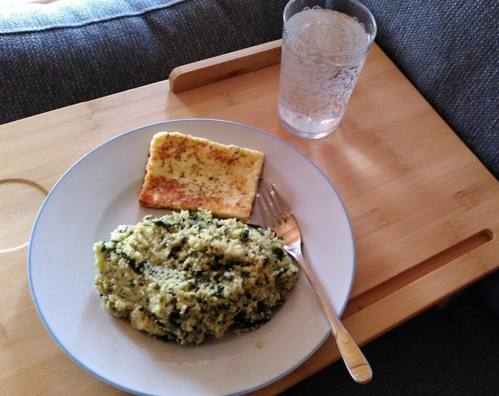 Essen und ein Glas mit Wasser auf einem Tablett