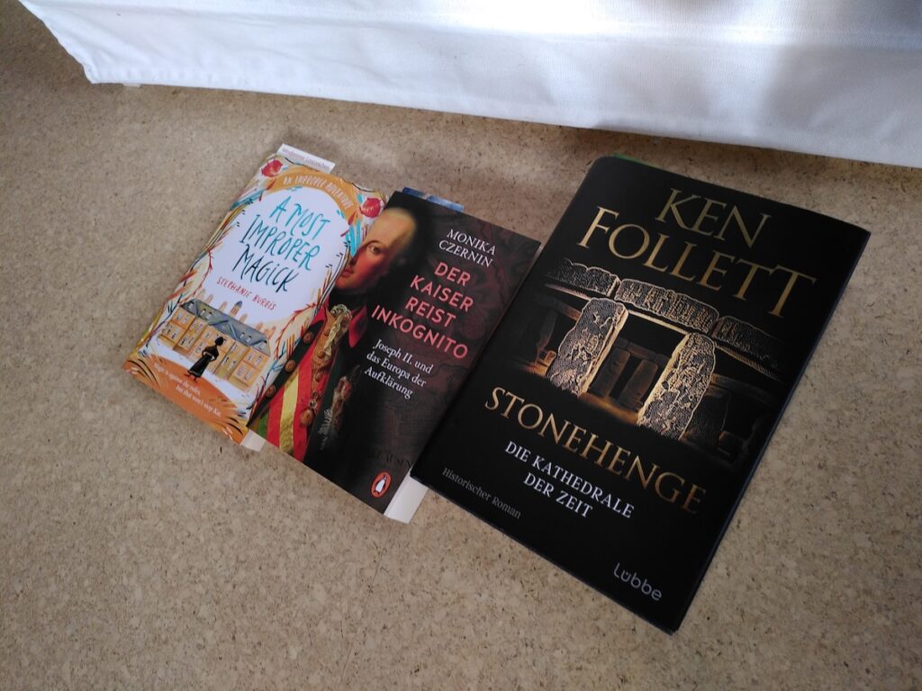 Die drei im Text genannten Bücher liegen nebeneinander auf dem Fußboden vor einem Bücherregal.